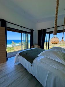 a bedroom with a bed and a view of the ocean at Le Moma by the ocean in Trois Bassins