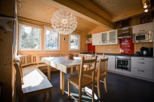 une cuisine avec une table et des chaises ainsi qu'un lustre dans l'établissement Alpenpark Turrach by ALPS RESORTS, à Turracher Höhe