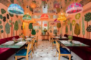 a dining room with long tables and chairs and lights at Laalee in Jaipur