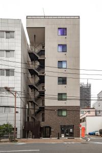 an apartment building with a fire escape at SOLASIA residence 北上野 in Tokyo
