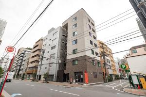 a tall white building on a city street at SOLASIA residence 北上野 in Tokyo