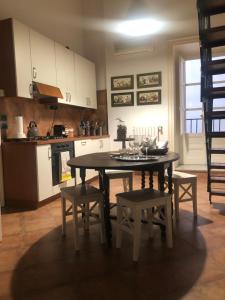 cocina con mesa y sillas y cocina con fogones en Casa degli Allori, en Palermo