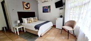 1 dormitorio con 1 cama y 1 silla en Thamalakane guest house en Maun