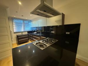a kitchen with a black counter top with a stove at Standard Villa in London