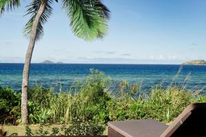 una vista del océano con una palmera en Sheraton Resort & Spa, Tokoriki Island, Fiji en Tokoriki
