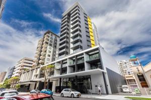 a tall building with cars parked in front of it at Kula Wollongong in Wollongong