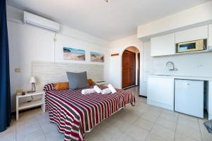 a bedroom with a bed with a striped blanket at Estudio Mirada 309 in Es Pujols