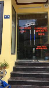 a front door of a building with signs in the window at Sapa Hostel - 679 Đường Điện Biên Phủ, TT. Sa Pa -by BayLuxury in Sa Pa