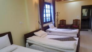 a room with three beds and a window at Sapa Hostel - 679 Đường Điện Biên Phủ, TT. Sa Pa -by BayLuxury in Sa Pa +2 photos