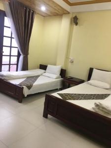 a room with two beds and a window at Sapa Hostel - 679 Đường Điện Biên Phủ, TT. Sa Pa -by BayLuxury in Sa Pa