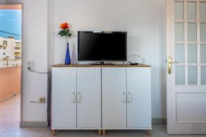 a white cabinet with a television on top of it at Apartamento los Hermanos in Es Pujols