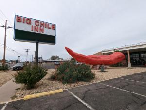 un grande cartello di una locanda di raffreddamento di fronte a un edificio di Big Chile Inn & Suites a Las Cruces