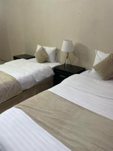 dos camas sentadas una al lado de la otra en una habitación en Arabian Palm Hotel, en Rabigh
