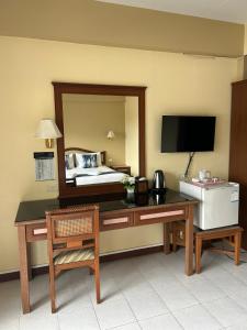 um quarto com uma secretária, uma cama e um espelho. em Lalisa Hotel Aonang em Praia de Aonang