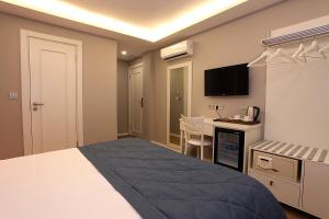 a bedroom with a bed and a desk with a television at Taksim Santa Lucia Hotel in Istanbul