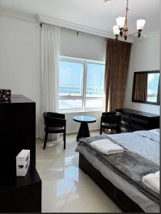 a bedroom with a bed and a desk and a table at Smart Home Vacation Home in Sharjah