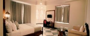 een slaapkamer met een bed, een bureau en een stoel bij The Biletha Bagh in Udaipur