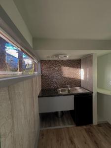 a small kitchen with a sink and a window at Ivybank Villa in Rothesay