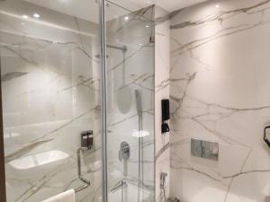 una doccia con una porta in vetro in un bagno di Maxxvalue Hotel MIDC - Andheri a Mumbai