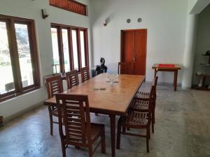 ein Esszimmer mit einem Holztisch und Stühlen in der Unterkunft Lucky Cottage in Galle