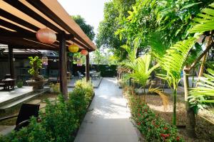 einen Garten mit Blumen und einem Fußweg in der Unterkunft Citrus Village Villa Hoi An in Hoi An