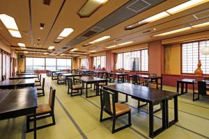 a dining room with tables and chairs and windows at Sumiyoshiya in Nagaoka