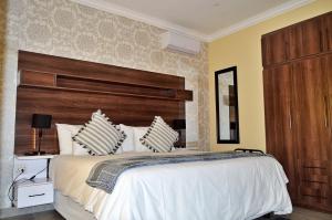a bedroom with a large bed with a wooden headboard at Royal Marlothi Kruger Safari Lodge and Spa in Marloth Park
