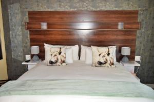 a bedroom with a large bed with a wooden headboard at Royal Marlothi Kruger Safari Lodge and Spa in Marloth Park