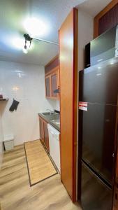 una cucina con frigorifero in acciaio inossidabile e mobili in legno di Lys Apartment a Gressoney-la-Trinité