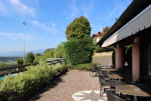 eine Terrasse mit Tischen und Stühlen auf einem Gebäude in der Unterkunft Albergo Alla Pineta in Montebelluna