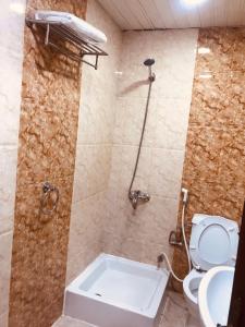 a bathroom with a shower and a toilet and a sink at العلمين للشقق المخدومة in Al Jubail