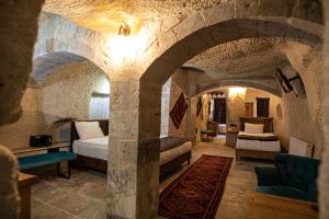 1 dormitorio con 2 camas en una habitación de piedra en Avilla Cave Hotel, en Göreme