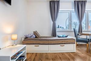 een slaapkamer met een bed, een bureau en een raam bij FeWo PeDa Nord in Norderstedt