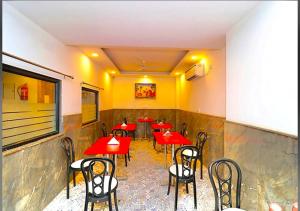 a dining room with red tables and chairs at Hotel Galaxy Inn Near Delhi International Airport in New Delhi