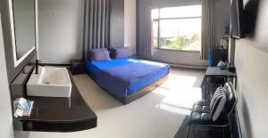 a bedroom with a blue bed and a window at Prai Fhan View in Mae Sai
