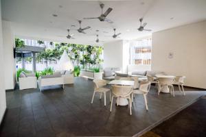 a large room with tables and white chairs at 188 suites By Seng Home in Kuala Lumpur