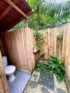 a wooden fence with a toilet in a backyard at Bohol Island Homestay in Dauis