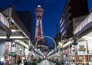 a city street with a tower in the background at APA Hotel Namba Shinsaibashi Nishi in Osaka