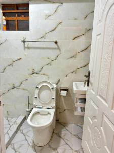 a white toilet in a bathroom with marble walls at Regency Stays III in Eldoret