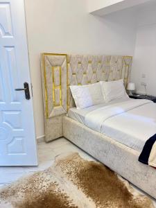 um quarto com uma cama grande e uma porta com um tapete em Regency Stays III em Eldoret