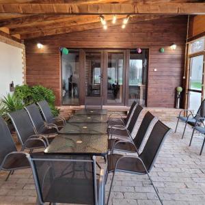 a long table and chairs on a patio at Végvári Vendégház in Magyarbóly