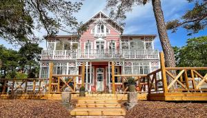 a large pink house with a large deck at Villa Maija 4 Upperside in Hanko