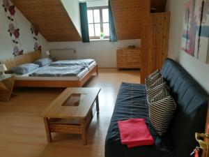 ein Wohnzimmer mit einem Sofa, einem Bett und einem Tisch in der Unterkunft Gästehaus Am Sonnenhang in Erbendorf