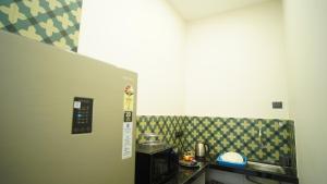 eine kleine Küche mit einer Theke und einer Mikrowelle in der Unterkunft The Colaba Pod in Mumbai