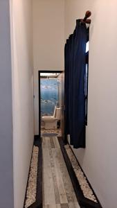 a bathroom with a toilet and a blue curtain at Taco Kings Place in Unawatuna