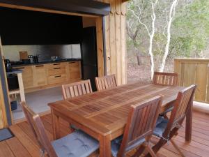 a wooden dining table and chairs in a kitchen at NIAOULI LODGE in Bourail