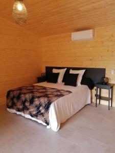 um quarto com uma cama grande num quarto de madeira em NIAOULI LODGE em Bourail