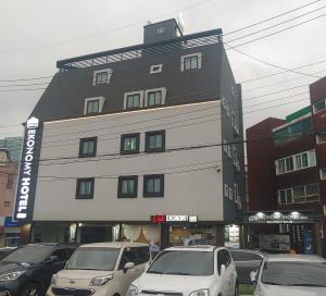 仁川的住宿－仁川經濟酒店，一座大型建筑,前面有汽车停放