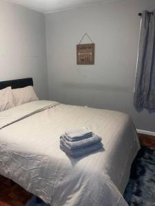 two towels are stacked on a bed in a bedroom at Miracle House in Brooklyn Park