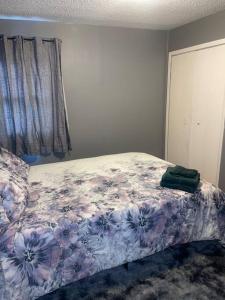 a bedroom with a bed with a flower patterned blanket at Miracle House in Brooklyn Park